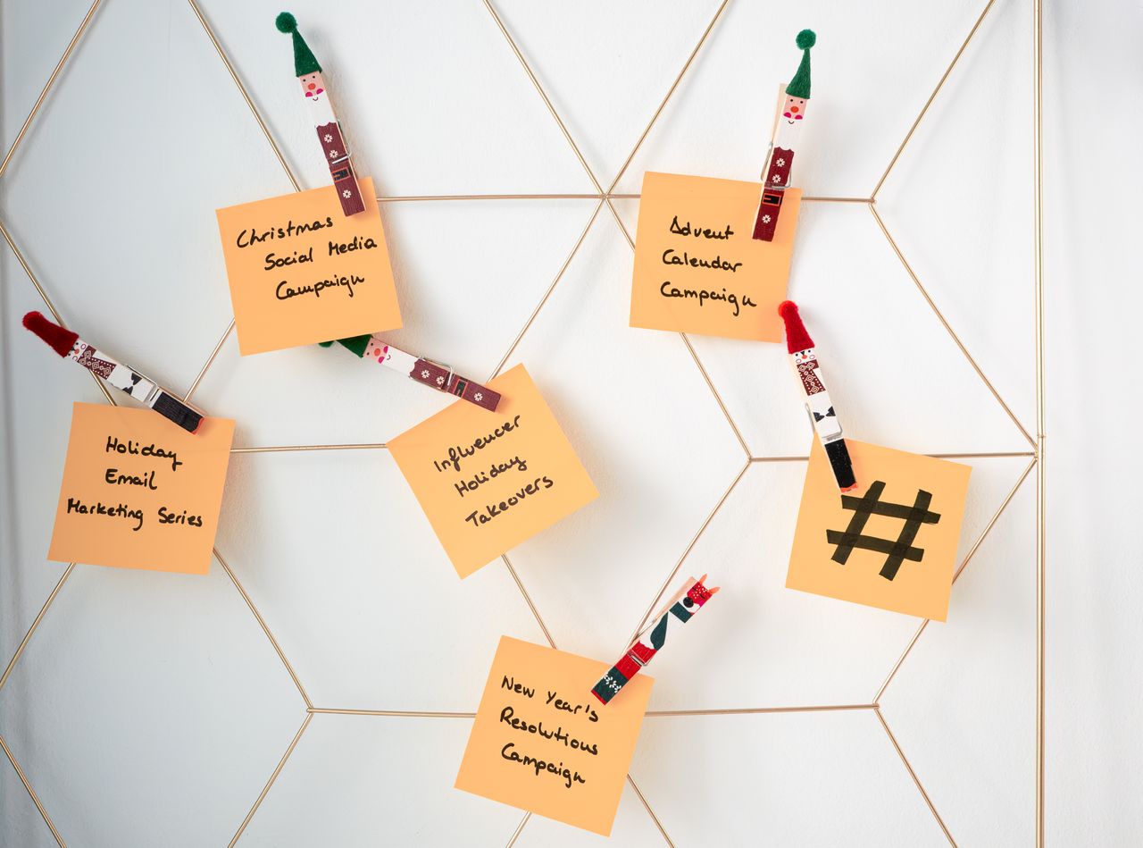 Des post-it avec des idées de marketing pour les fêtes, fixés sur une grille murale.